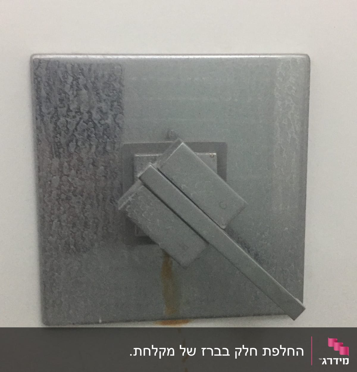 ברז מתכת עם כתמי חלודה על הקיר
